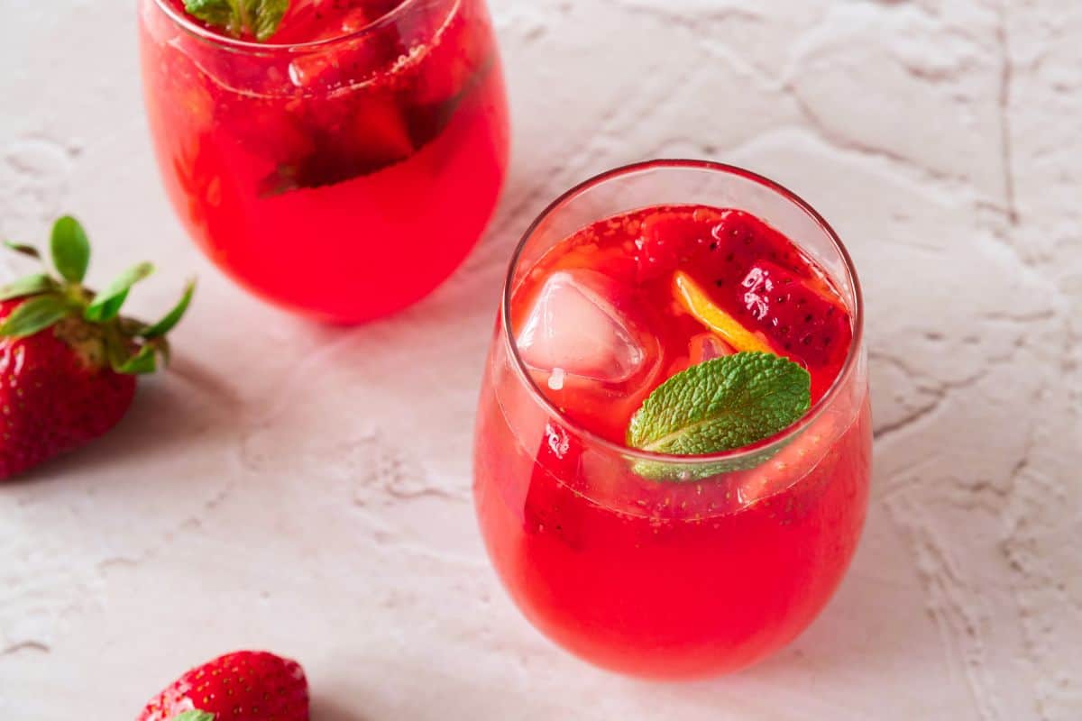 top view of strawberry flavored lemonade in glass with mint and ice.
