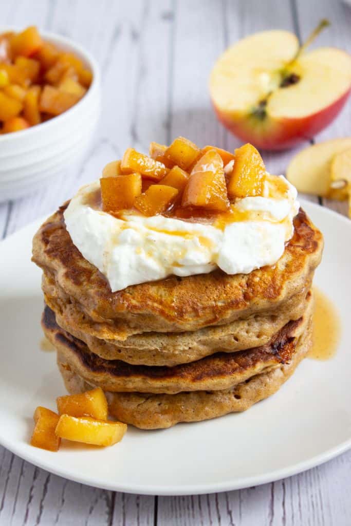 stack of apple pancakes topped with yogurt and apple compote.