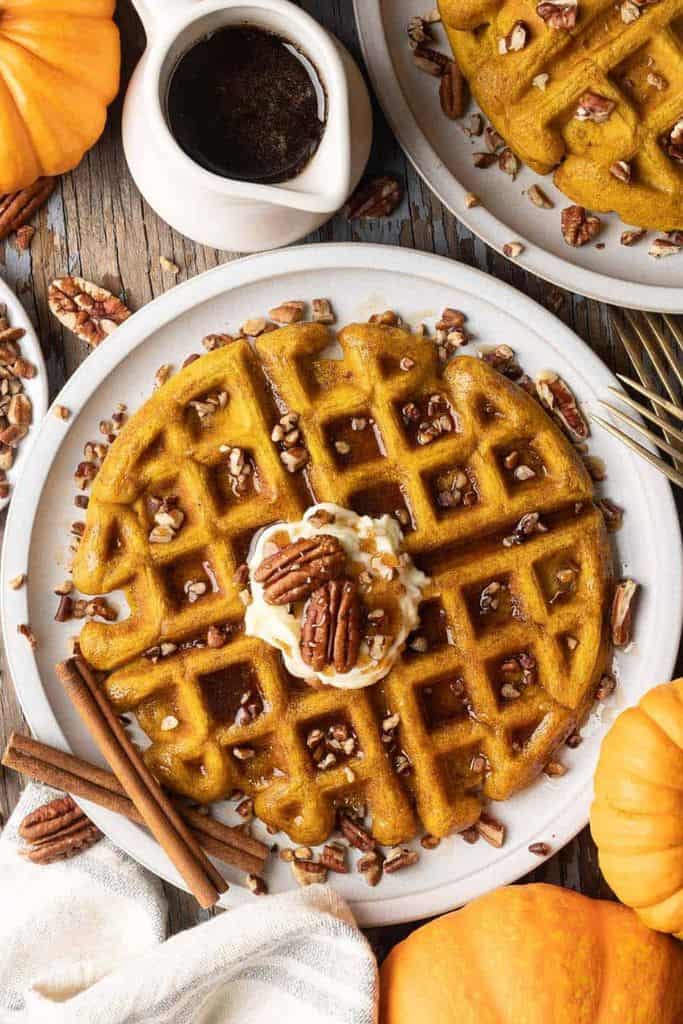 pumpkin waffle topped with syrup and pecans.