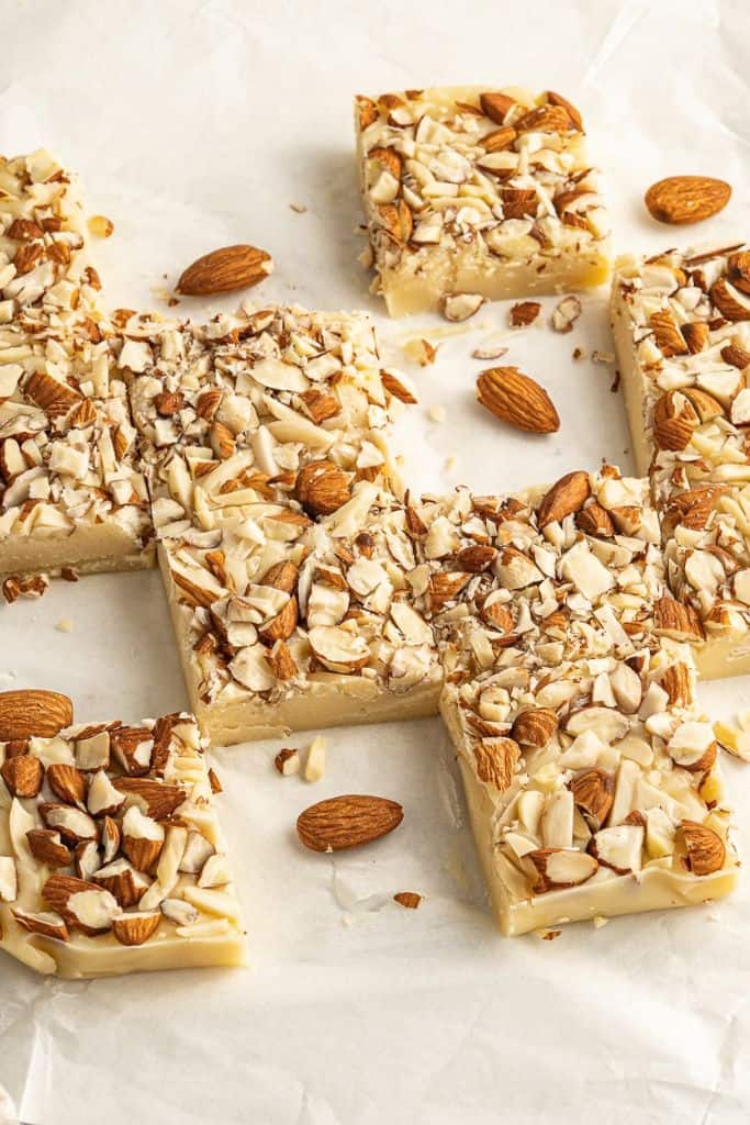 white chocolate fudge with almonds on parchment paper.