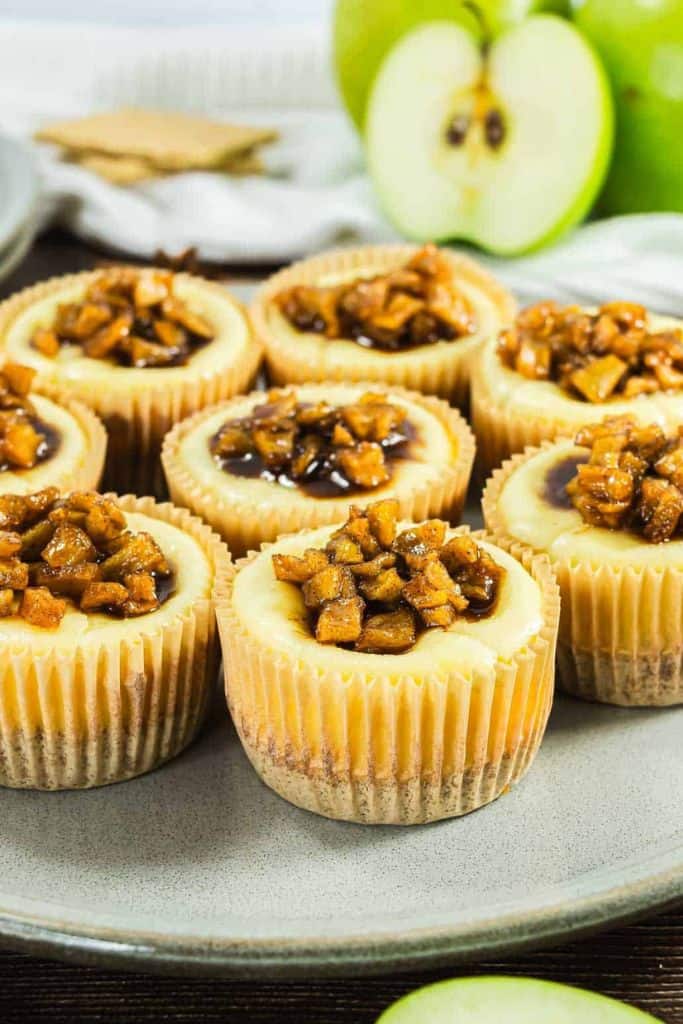 individual apple cheesecakes on platter.