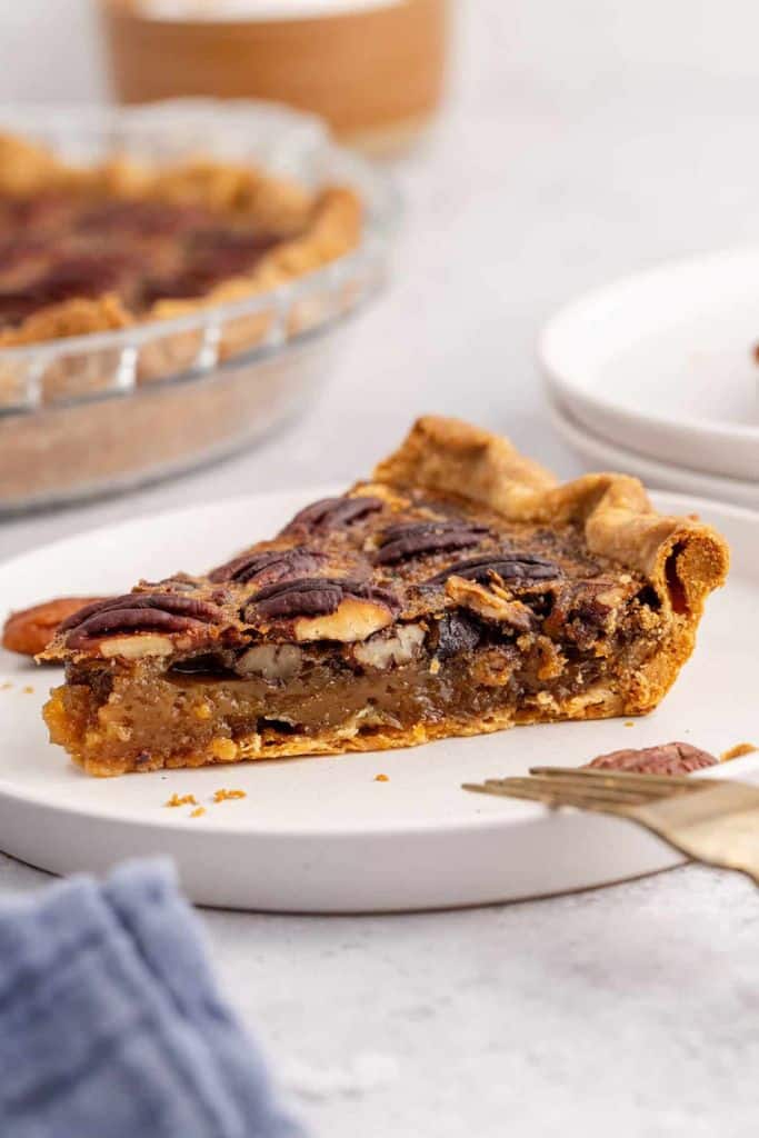 slice of copycat costco pecan pie on white plate.