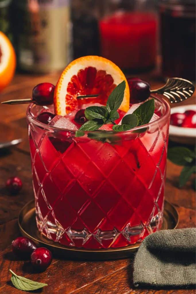 cranberry mocktail in glass with garnish.