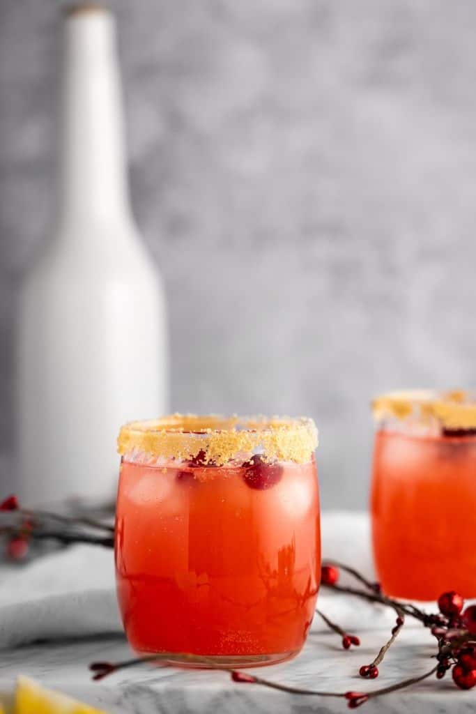 cranberry drink in glass with brown sugar on rim.
