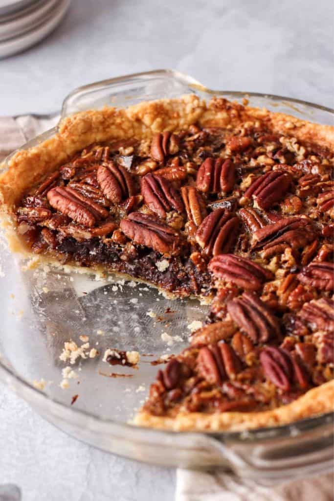 dark chocolate bourbon pecan pie in glass pie dish.