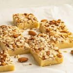 pieces of white chocolate fudge topped with nuts.