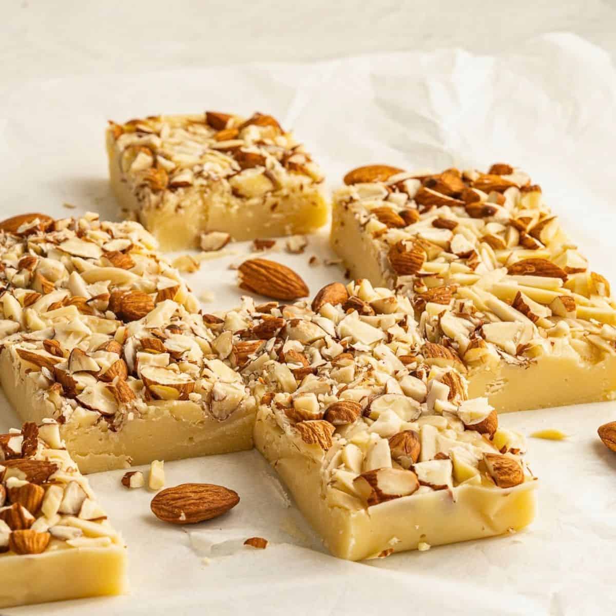 pieces of white chocolate fudge topped with nuts.
