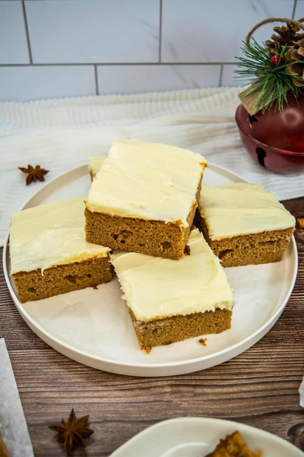 plate with squares of gingerbread dessert cake, frosted with cream cheese icing.
