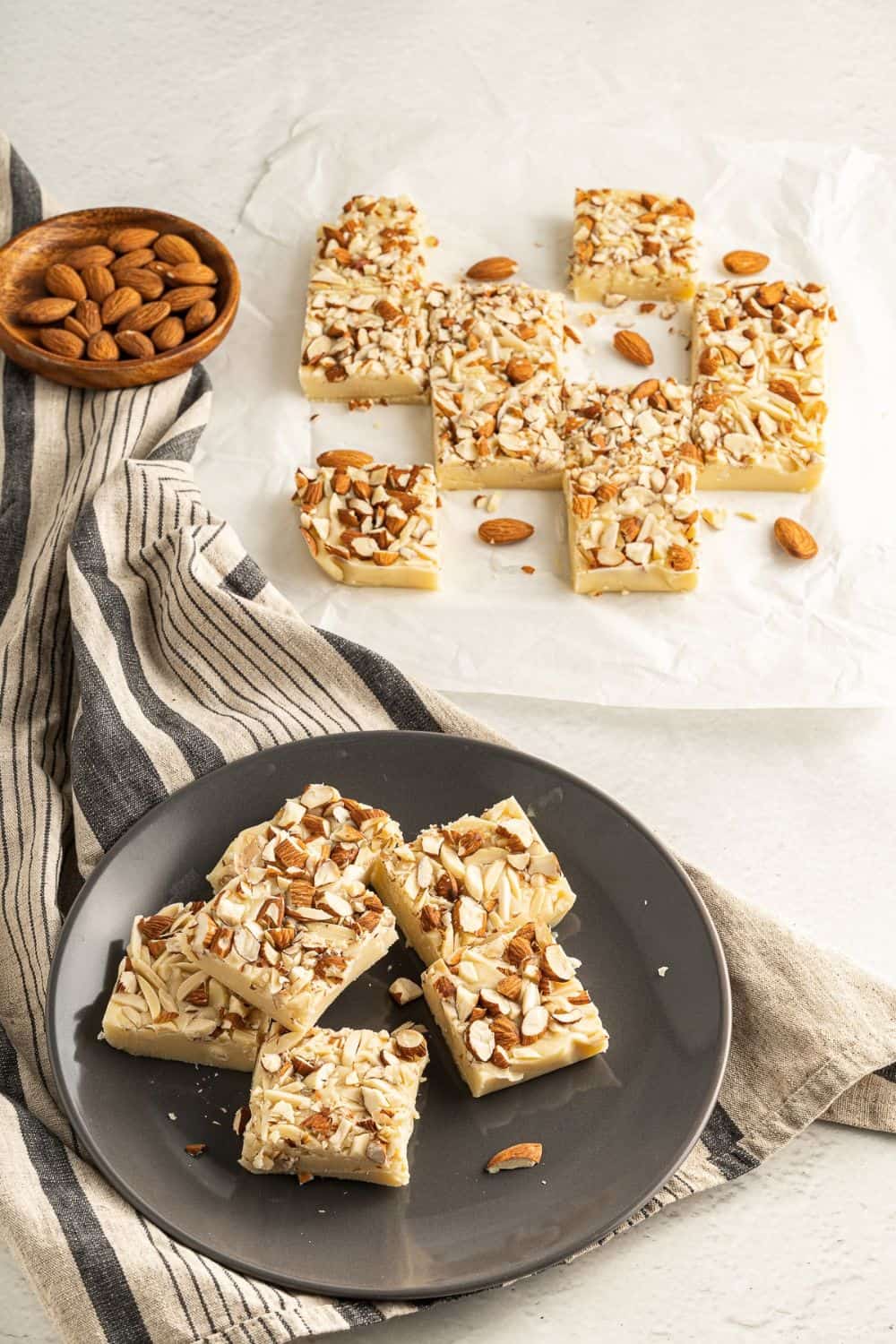 white fudge squares on plate and alongside on parchment paper.