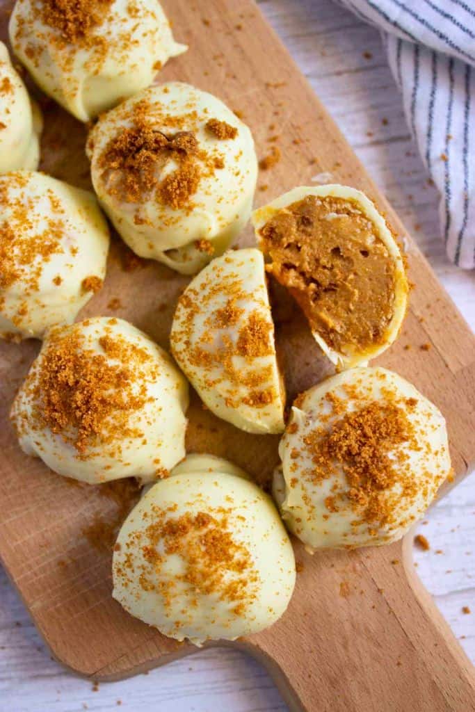 pumpkin cheesecake truffles on wooden board.