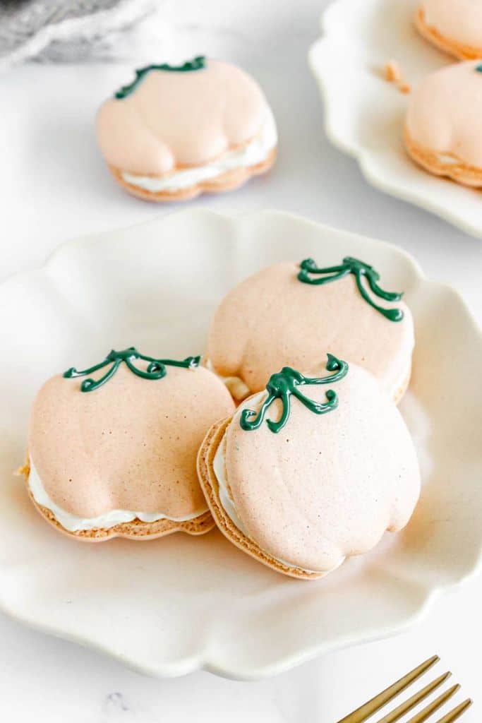 pumpkin macarons on plate.