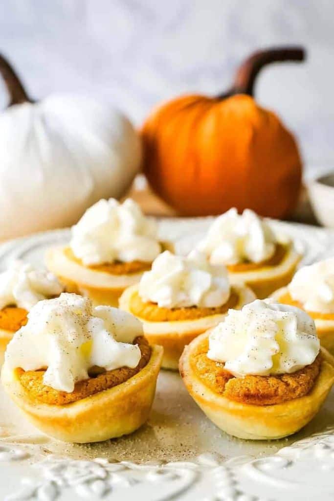 small pumpkin pie bites with cream on plate.