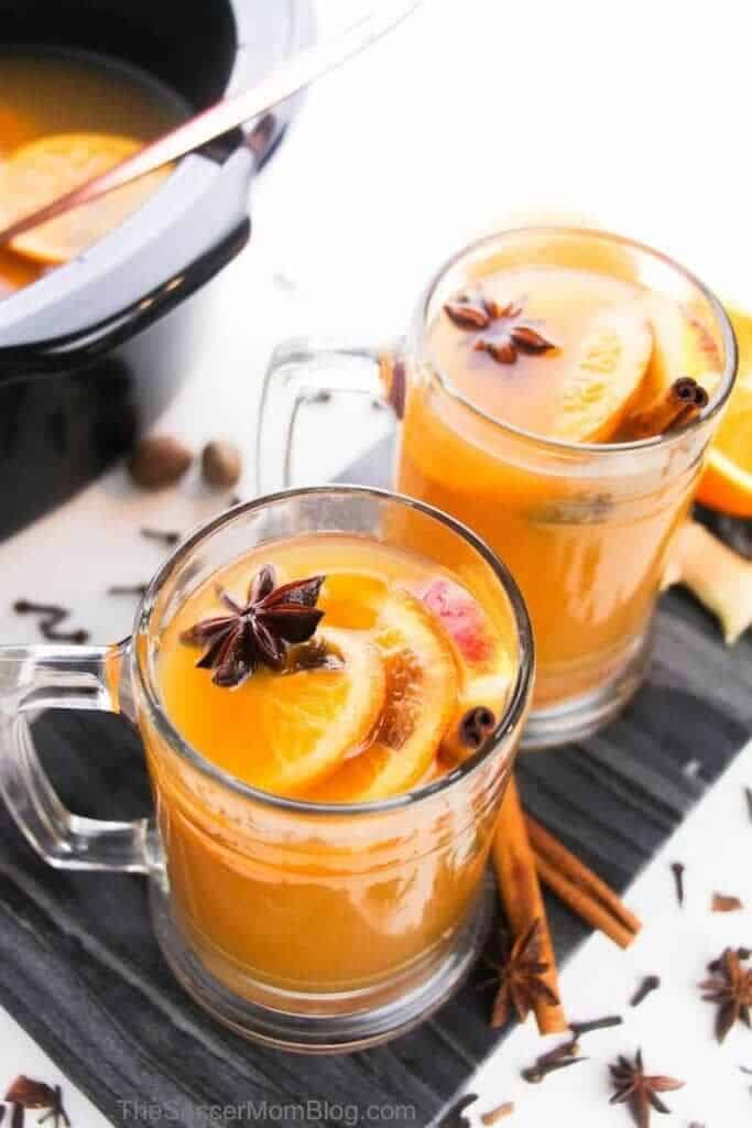 apple cider with spices and fruit in glass.