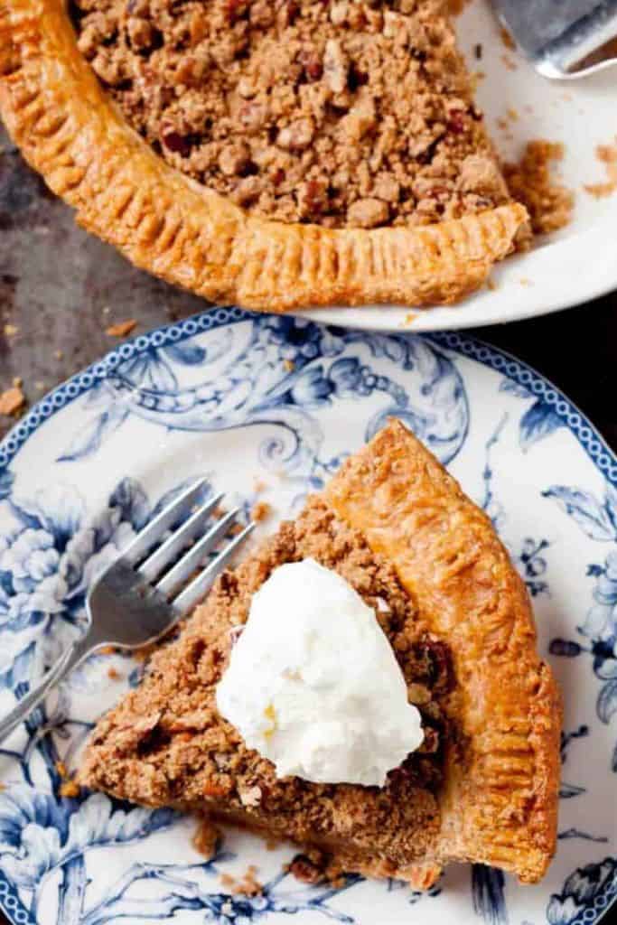 slice of sweet potato pecan pie with dollop of cream.
