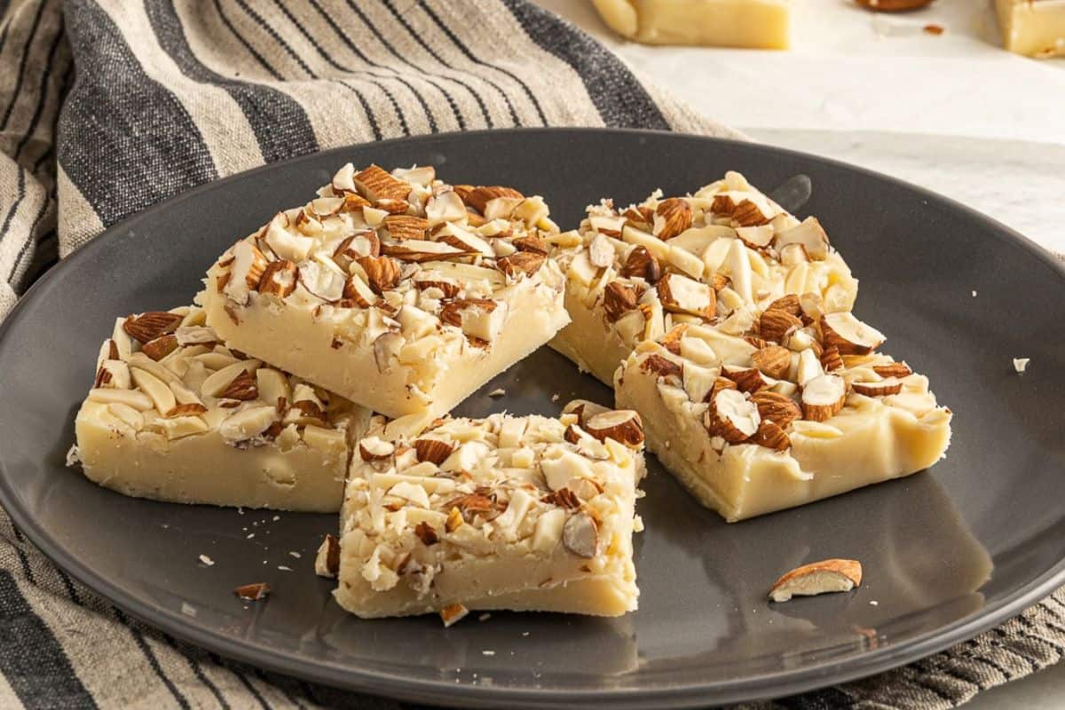 white chocolate fudge squares on black plate.