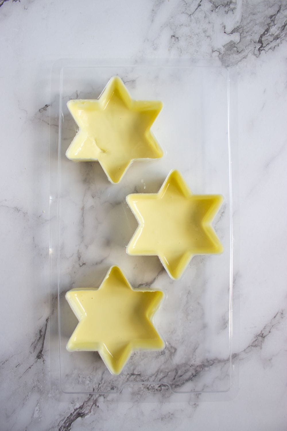 melted white chocolate in snowflake star shaped molds.