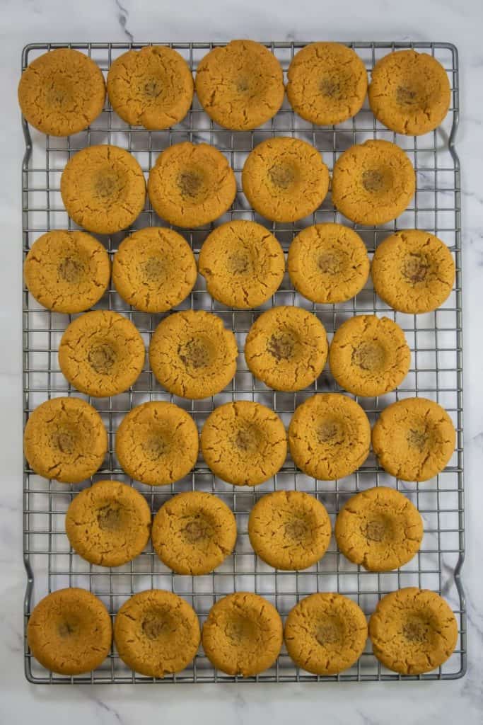 baked thumbprint cookies on wire rack.