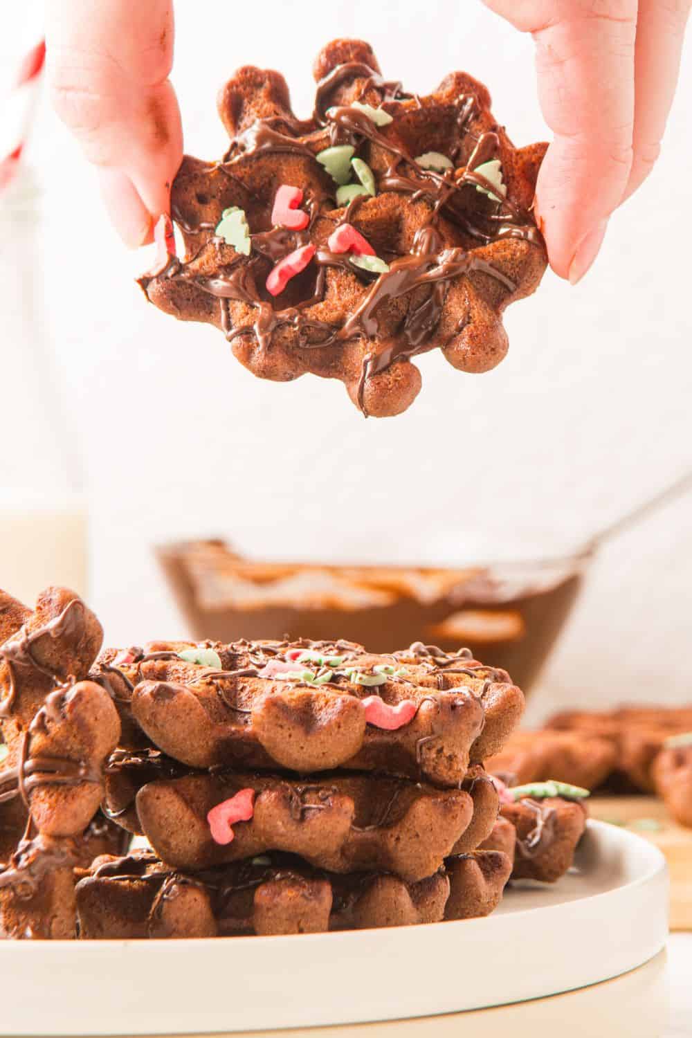 stack of waffle cookies with one mid-air.