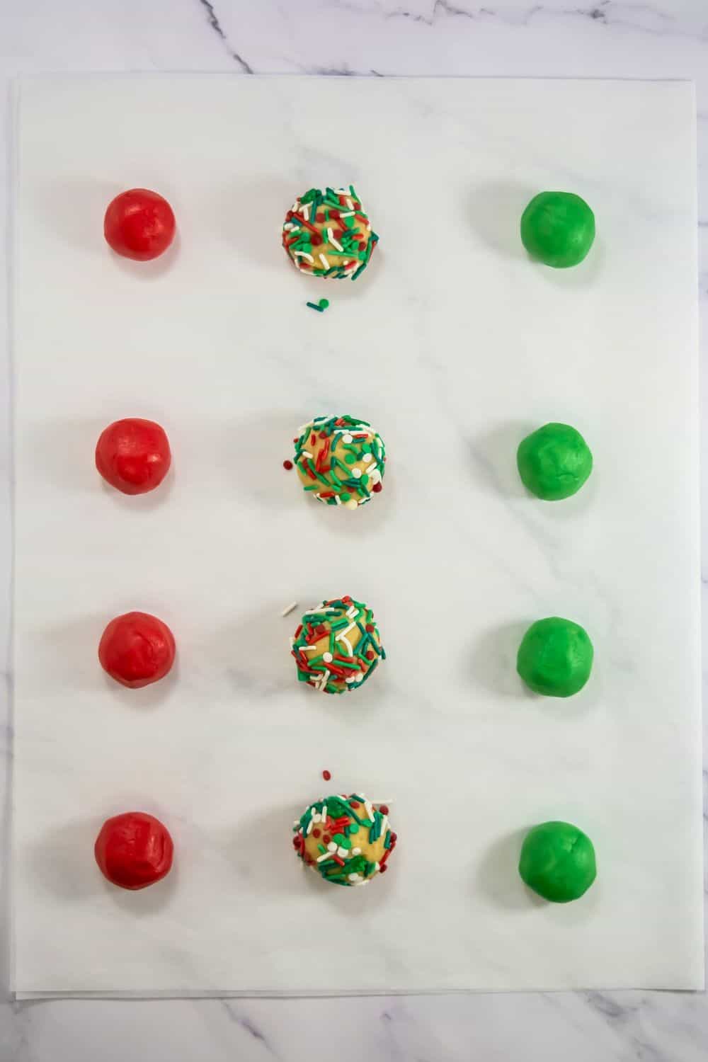 festive cookie balls rolled on parchment paper.
