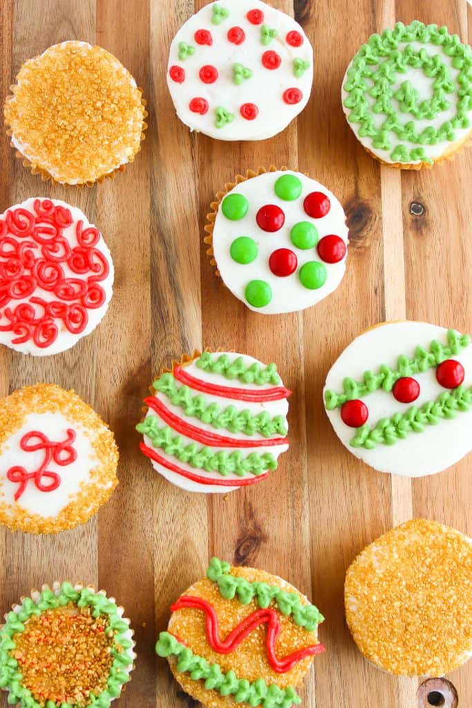 decorated christmas cupcakes on wooden board.