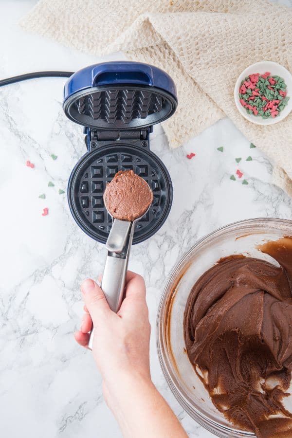 scoop of cookie batter above waffle iron.