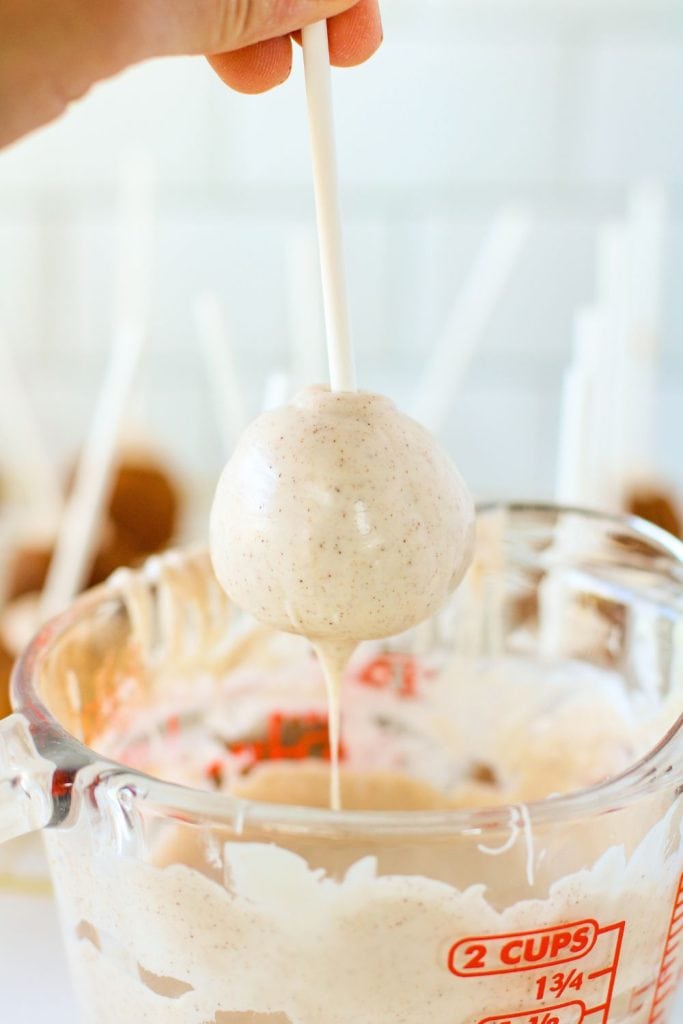 dipping cake pop into white chocolate.