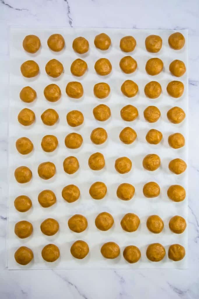 rolled cookie balls on parchment paper.