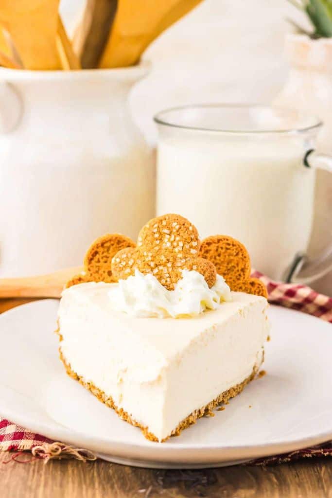 no bake gingerbread cheesecake slice on plate with gingerbread cookies.