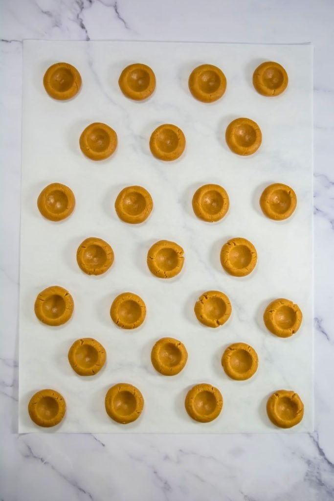 unbaked thumbprint cookies on parchment paper.