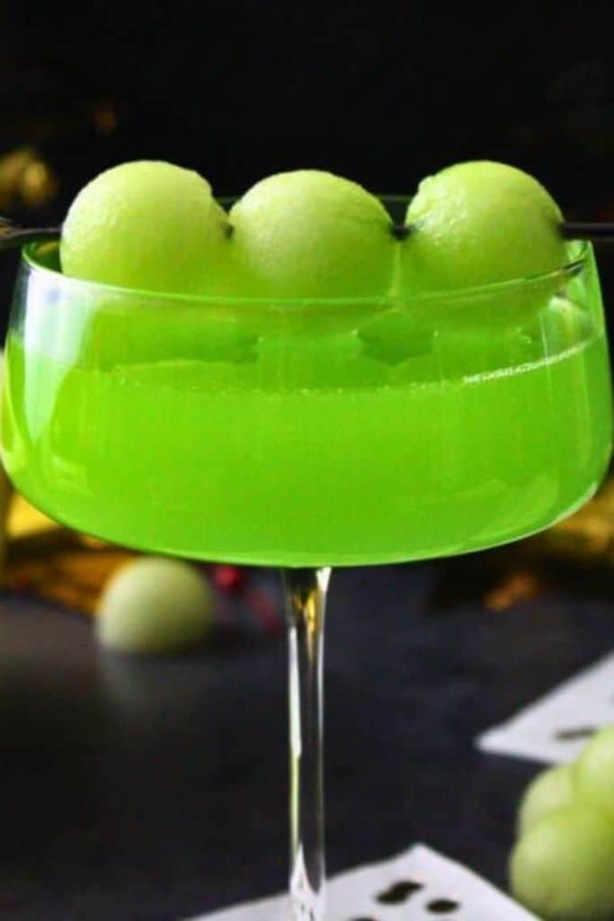 green nye cocktail with melon balls.