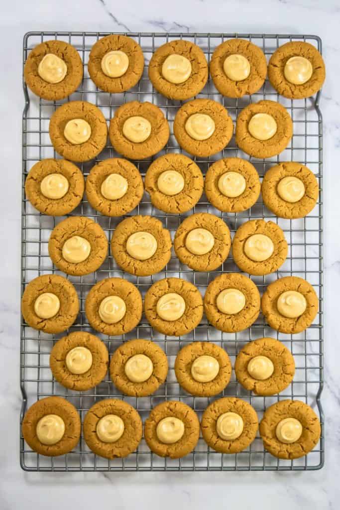filled gingerbread cookies on wire rack.