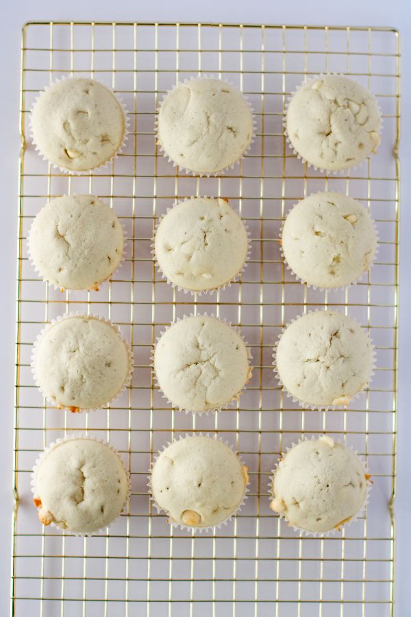 baked white cupcakes on wire rack.