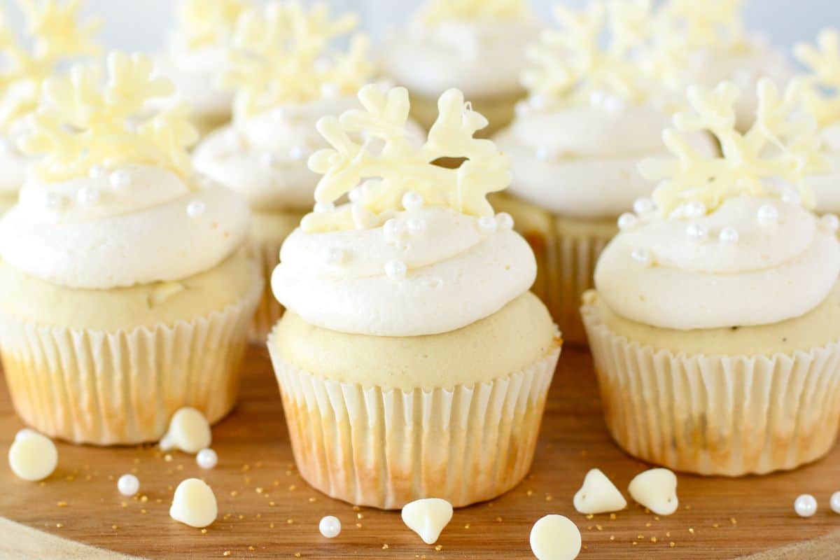 white chocolate cupcakes with edible snowflake cupcake toppers and nonpareils.